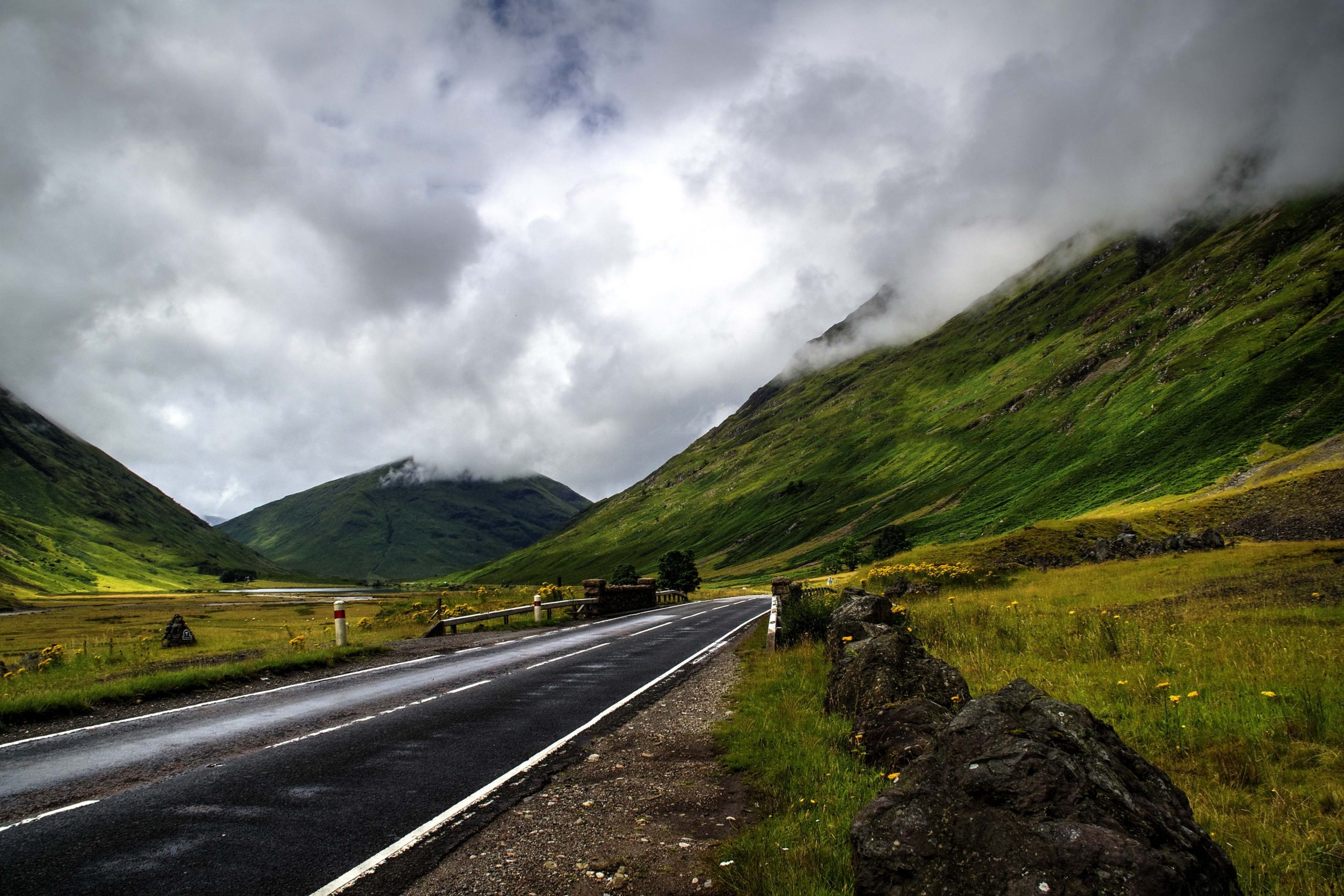 A beautiful shot of the road surrounded by mountains under the cloudy sky